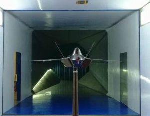 Figure 3: The interior of the wind-tunnel test section — the model is held at the centre of the airflow by its support rig, with the contraction section visible downstream. Tracker segment models have their critical points measured by step-by-step wind-speed increases in exactly such a test section.